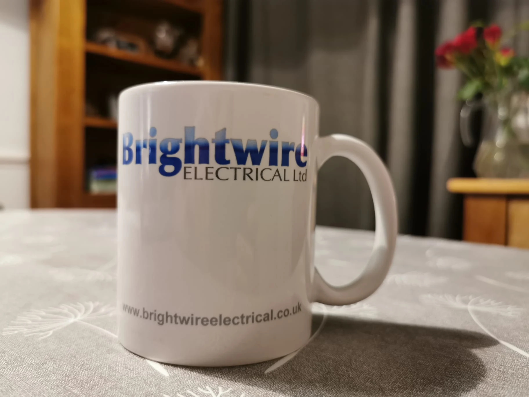 A mug bearing the Brightwire Electrical logo.