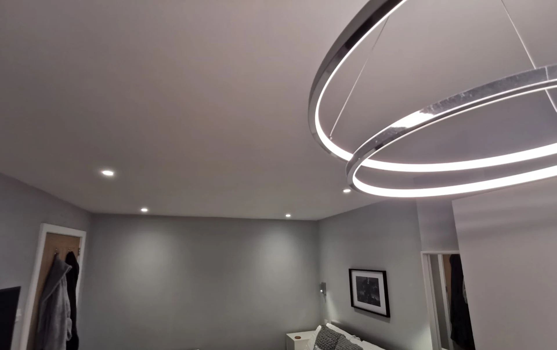 Ceiling downlights and a circular pendant light in a home.
